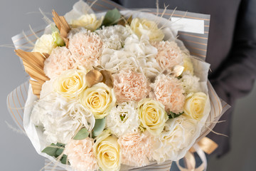 Beautiful bouquet of mixed flowers in womans hands. the work of the florist at a flower shop. Fresh cut flower.