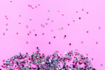 Abstract festive background with sparkles and glitter on a pink background.