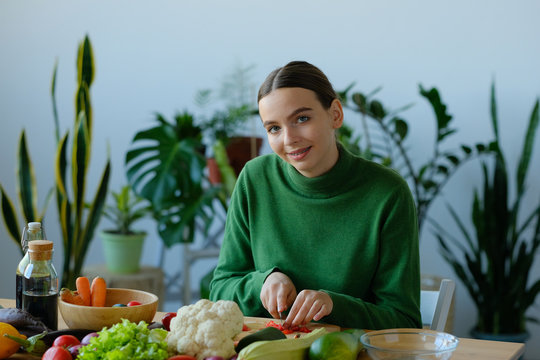 girl slices tomatoes to make a salad. - Powered by Adobe