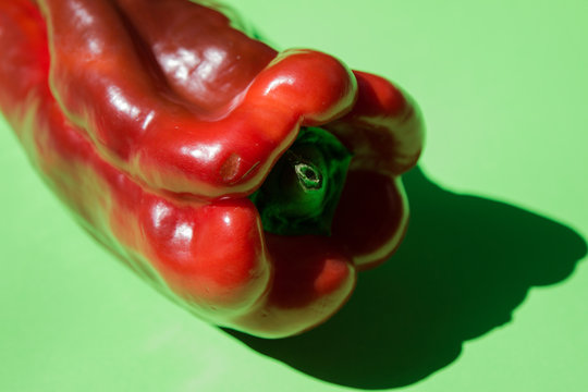 Large pepper with shadow on a green background