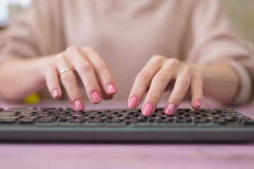 Woman typing on the keyboard. Housewife works at the computer.