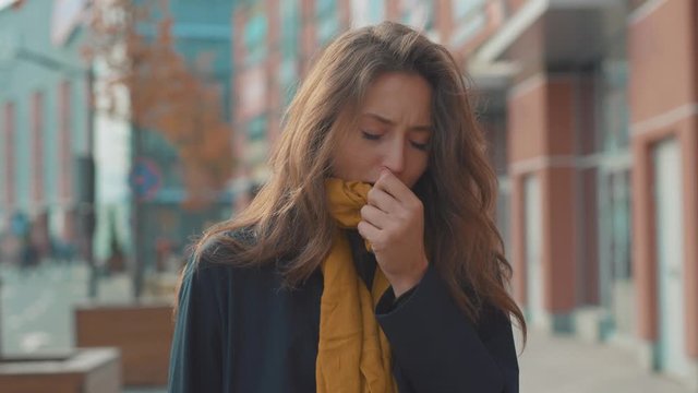 Face young woman stand coughs feel sick at outdoor fever cold allergy city beautiful disease female nose sneeze lady runny tissue air pollution adult illness district slow motion