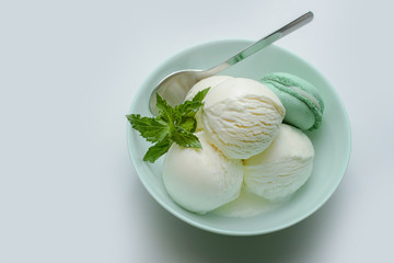 Balls of fresh ice cream with a sprig of mint and mint macaroon.