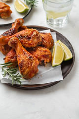 Chicken legs with sauce, rosemary and lime on a white background. Copy space.
