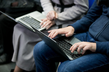 A picture of laptop. Girl holds it on her lap. She has her fingers on its keyboard. Woman types....