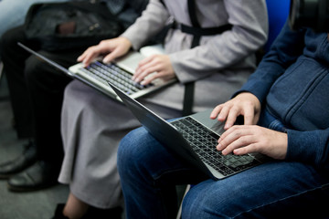 A picture of laptop. Girl holds it on her lap. She has her fingers on its keyboard. Woman types. She works