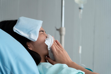 Sick young woman with seasonal infections flu admitted in the hospital.