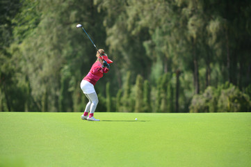 The golf player shooting the golf ball