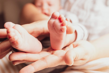 Obraz na płótnie Canvas baby feet in mothers hands
