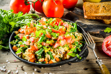 Mexican Southwestern Egg Scramble, Simple healthy breakfast idea with eggs and vegetables, with toast. Wooden background copy space