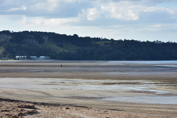 Exposed sand flats of Snells Beach at low tide with hills of Mahurangi East in background.