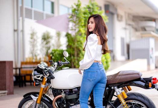 Outdoor lifestyle portrait of asian beautiful biker girl and motorcycle