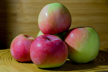 Image of apples on a beige, wooden background.