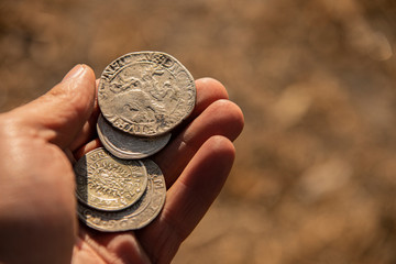 ancient silver coins in hand