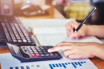 Business concepts, the hands of business women are calculating the company's income. (Focusing only on certain areas , Tone film with Grain and Noise)