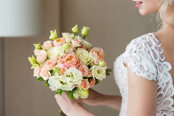 Bridal bouquet. Wedding bouquet in the hands of the bride. Close-up interior studio shot against dark background