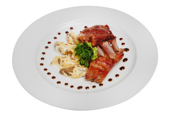 Fried rib steak with green on plate on white isolated background