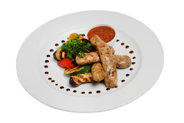 Grilled sausages with zucchini and sauce on a plate on a white isolated background