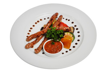 Grilled sausages with zucchini and sauce on a plate on a white isolated background