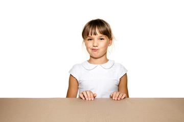 Cute and astonished little girl opening the biggest postal package. Excited young female model on top of cardboard box looking inside. Gift, present, delivery, shipment, sales, black friday concept.