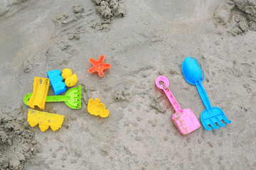 Fototapeta na wymiar Children's Toys on sand beach background.