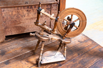 Old spinning wheel. Vintage tailoring equipment concept.