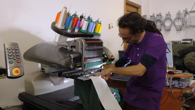 Man tailoring with automated Embroidery machine in the studio.Tailoring,art