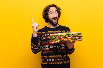 young crazy bearded man with a giant sandwich.