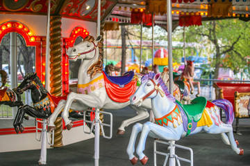 Merry-go-round with horses. Carousel with horses. Amusement Park in the city