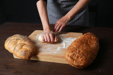 cooking fresh bread from flour on a table on a black background