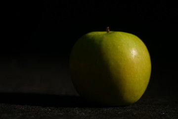 green apple on wooden table.