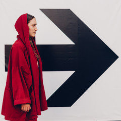 Young woman in red staying near arrow sign. Success concept