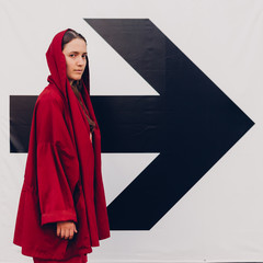 Young woman in red staying near arrow sign. Success concept