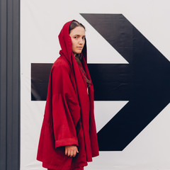 Young woman in red staying near arrow sign. Success concept