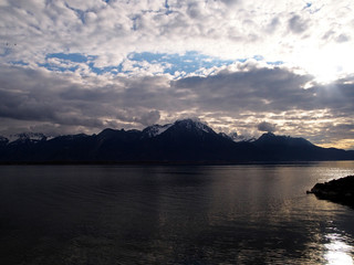 Sunset on the Lake Geneva - Switzerland. Mountain ranges and trees on a winter day.