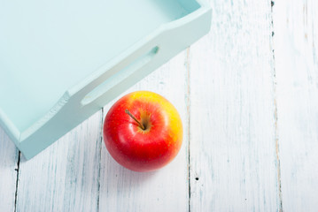 apples at blue tray, white wood table