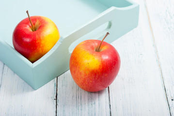 apples at blue tray, white wood table