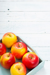 apples at blue tray, white wood table