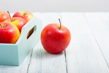 apples at blue tray, white wood table