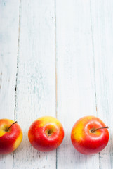 apple fruits in a row, white wooden table background