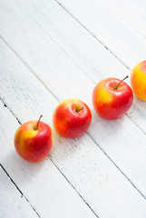 apple fruits in a row, white wooden table background