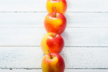 apple fruits in a row, white wooden table background