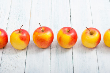 apple fruits in a row, white wooden table background
