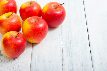 apple fruits in a row, white wooden table background