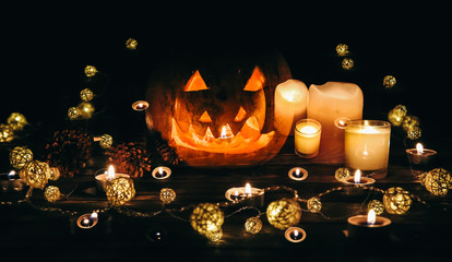 Halloween pumpkin in the darkness. Lights lamps and candles. Mystical autumn holiday. Festive details. Trick-or-treat tradition. All Saints day in October.