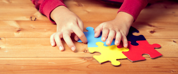 Banner picture of an autistic child's hands playing a puzzle symbol of Public awareness for autism...
