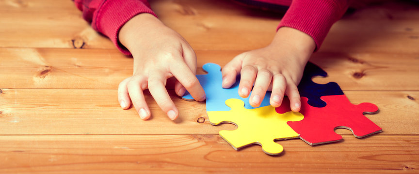 Banner picture of an autistic child's hands playing a puzzle symbol of Public awareness for autism spectrum disorder. World Autism Awareness day April 2, Supportive, Understanding and Acceptance.