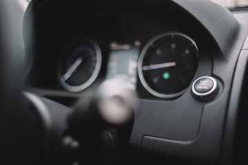 Fototapeta premium Close up photo of start-stop button in car. Selective focus, blurred dashboard on background. Road trip concept. Ecology concept. Start the automobile. Premium trim materials.