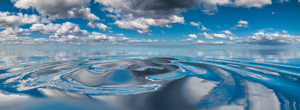 Clouds reflected in circular water ripples
