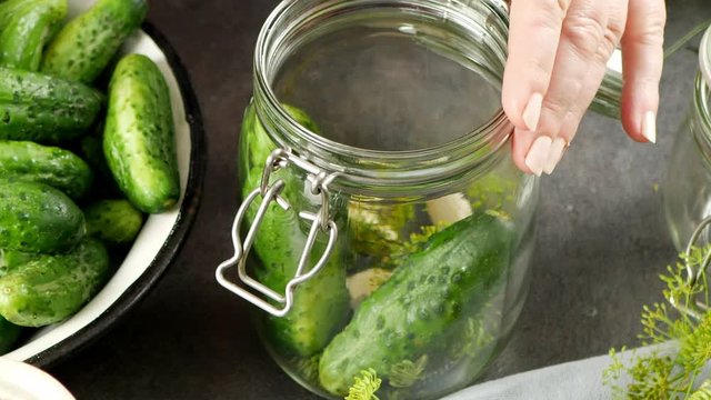 Putting cucumbers and spices in a jar. Close up of a jar. Tight frame.